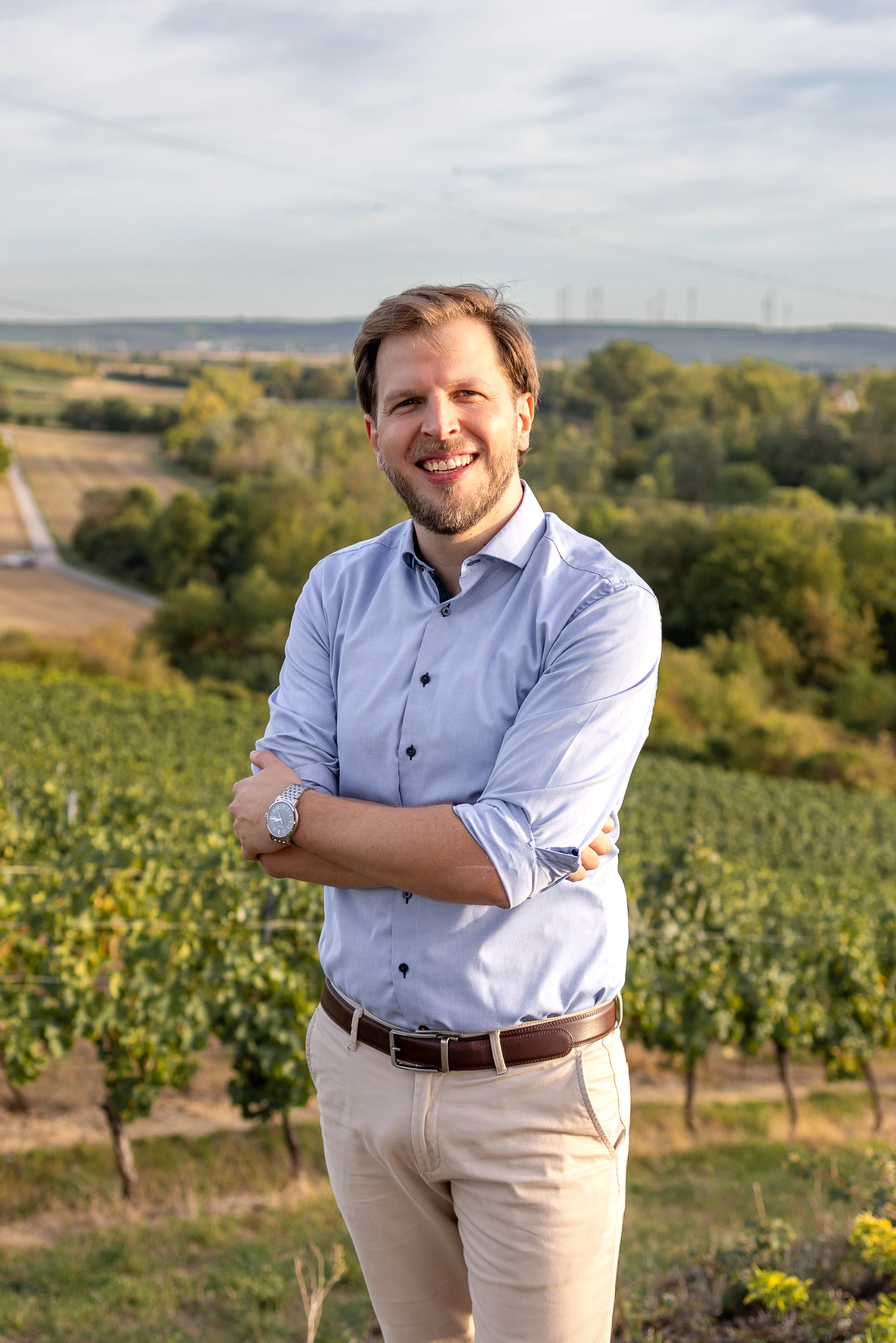 Porträt von Martin Heitfeld vor der rheinhessischen Landschaft am Dreiseenblick